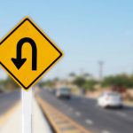 U,Turn,Sign,On,Road,Blurred,Background