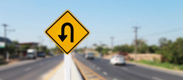 U,Turn,Sign,On,Road,Blurred,Background