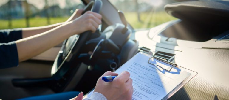 Examiner,Filling,In,Driver's,License,Road,Test,Form,Sitting,With