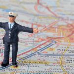 Miniature,Figurine,Of,A,Traffic,Policeman,On,A,Road,Map