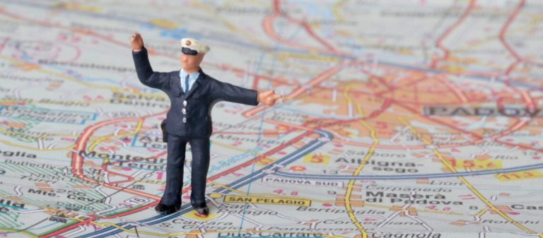 Miniature,Figurine,Of,A,Traffic,Policeman,On,A,Road,Map