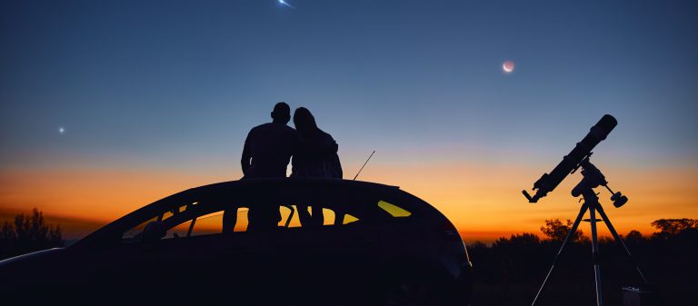 Couple,Stargazing,Together,With,A,Astronomical,Telescope.