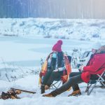 Man,With,Woman,Sitting,On,Chairs,Near,Camp,Fire,In