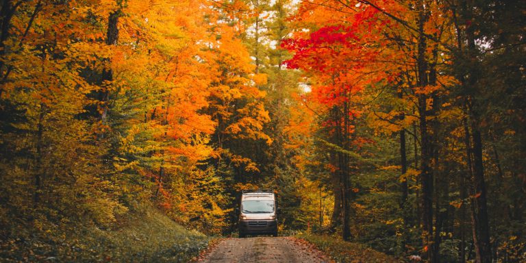 Epic,Camper,Van,Drives,On,Dirt,Road,In,Colorful,Autumn